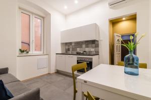 una cucina con tavolo e vaso di Elegante appartamento da 6 Blu&Oro a Trieste