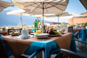 un tavolo con un piatto di frutta sopra di Hotel Ideal a Limone sul Garda