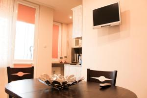 a dining room with a table and a television on a wall at Cosmo Apartment Pleven in Pleven