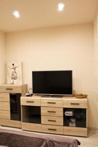 a flat screen tv sitting on top of a wooden entertainment center at Cosmo Apartment Pleven in Pleven