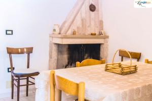 a dining room with a table and a fireplace at Trullo Cittadino in Cisternino