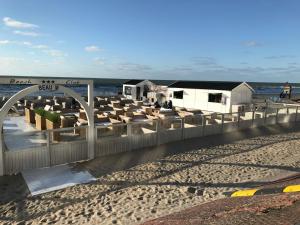 einen Strand mit einem Zaun und Strandhütten in der Unterkunft Residentie Sorrento in Middelkerke