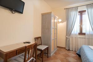 Cette chambre comprend une table, un lit et un bureau. dans l'établissement Bed & Breakfast Al Pian d'Assisi, à Assise