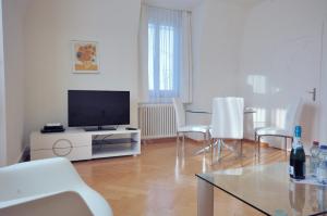 チューリッヒにあるSpacious 2-bedroom near lake - Stardust 32のリビングルーム(テレビ、テーブル、椅子付)