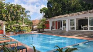 a swimming pool in front of a house at Hotel Reggia Catarina in Petrópolis