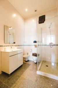 a bathroom with a toilet and a sink and a shower at Torrinha House in Lagos