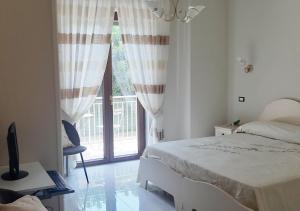 a bedroom with a bed and a window with a balcony at Domus In Fonte in Scafati