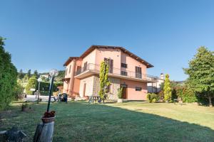 a large house in a yard with a grass field at Bed & Breakfast Al Pian d'Assisi in Assisi
