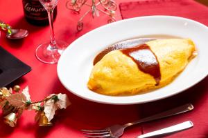 a white plate of food on a red table at Nagasaki Chapel Coconuts Hotel ＆Resort in Isahaya