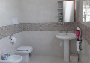a bathroom with a white toilet and a sink at Domus In Fonte in Scafati