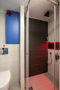 a bathroom with a shower with a red cross on the wall at apt.27-102 in Nafplio