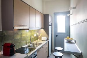 a kitchen with a sink and a counter with stools at apt.27-102 in Nafplio