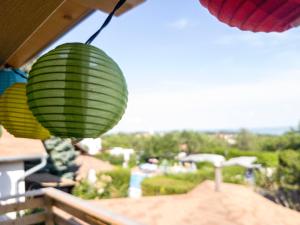 two green and yellow lanterns hanging from a balcony at Mandel Camping in Paloznak