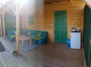 a porch of a wooden cabin with a green door at Mandel Camping in Paloznak