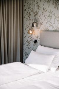 
a white bed with white sheets and pillows at Garni-Hotel Der Forsterhof in Lagundo
