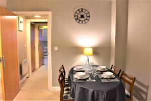mesa de comedor con mantel negro y sillas en Bard's Nest, Crucible Apartment, FREE private parking, 3 mins walk to Birthplace, en Stratford-upon-Avon