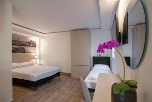 een slaapkamer met 2 bedden en een tafel met een bloem bij Casa Mia in Budva