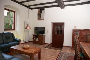 ein Wohnzimmer mit einem Sofa und einem TV in der Unterkunft Schloss Fischbach in Eisenach
