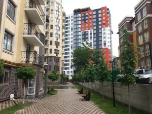 a city street with benches and tall buildings at Apartment Studio PARIS 2 in Irpin