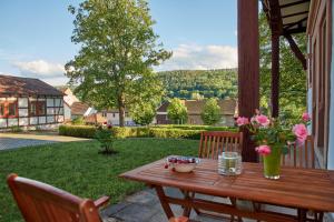 einen Holztisch mit einer Vase aus Blumen auf einer Terrasse in der Unterkunft Schloss Fischbach in Eisenach