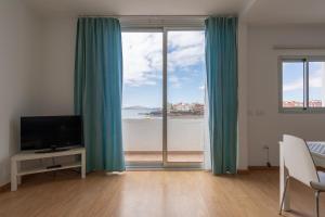 a room with a large window with a view of the beach at VISTA PLAYA Y MAR - sea view, wifi and AC in Melenara