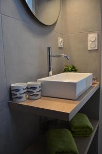 ein Badezimmer mit Waschbecken und zwei Tassen im Regal in der Unterkunft LA MAISON DE BIORD in Saint-Jacut-de-la-Mer + 32 Fotos