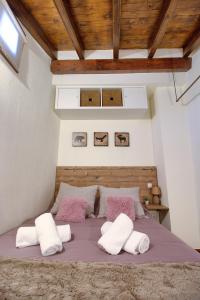 1 dormitorio con 1 cama con almohadas rosas y blancas en La Buhardilla de Andrea, en Cuenca
