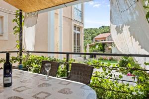 a table with a bottle of wine on a balcony at Apartments Marina in Šibenik