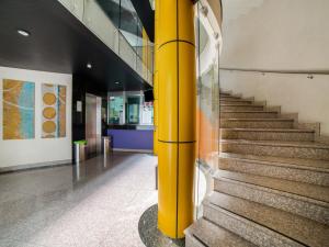 a yellow column in a building with stairs at Hotel Via La Villa in Mexico City
