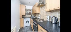 a small kitchen with a washer and dryer in it at No 1 - LARGE 1 BED NEAR SEFTON PARK AND LARK LANE in Liverpool