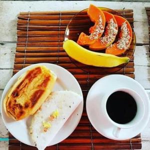 Adios Amigos Hostel في ارايال دايودا: طاولة مع طبق من الطعام وكوب من القهوة