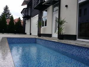 a swimming pool in front of a house at APARTMANI LAVAZZA in Vlasotince
