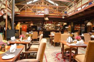 a restaurant with wooden tables and chairs and a bar at Kongoni Camp in Nanyuki