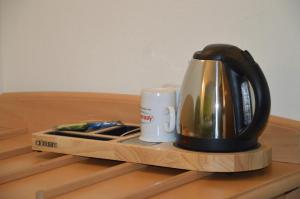 einen Wasserkocher und eine Kaffeetasse auf dem Tisch in der Unterkunft Pension Zueschener Bauernstuben in Winterberg