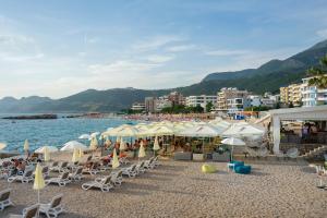 a beach with umbrellas and chairs and the water at Apartments Vila A1 in Dobra Voda