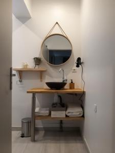 a bathroom with a sink and a mirror at Chambre d'hôtes du Pin in Pey