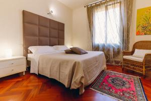1 dormitorio con 2 camas, silla y ventana en Exclusive Aparthotel La Reunion, en Rávena