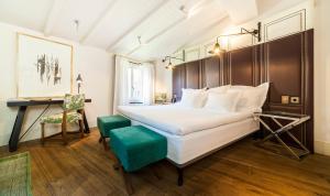 - une chambre avec un grand lit blanc et une chaise dans l'établissement Hotel Cort, à Palma de Majorque