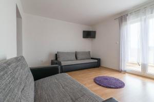 een woonkamer met een bank en een raam bij Apartment Summer in Sukošan