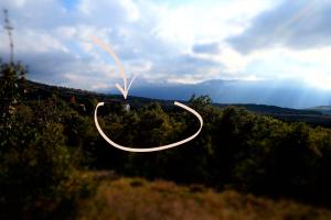 a couple of rings flying in the sky over a forest at Pezzelelle in Roccamorice