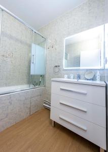 a white bathroom with a sink and a shower at Première ligne de plage, face à la mer in Hendaye