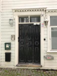 a black door of a house with a window at Bergen City Apartments Halvkannesmauet in Bergen