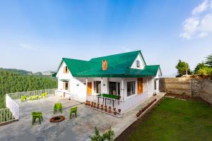 una piccola casa bianca con tetto verde di Zostel Homes Theog (Shimla) a Theog