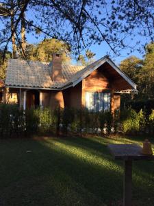 una casa con techo de tejas en un patio en Pousada Villa do Luar, en Monte Verde