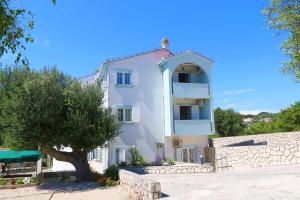 a white building with a tree in front of it at Apartments Delminium in Lun