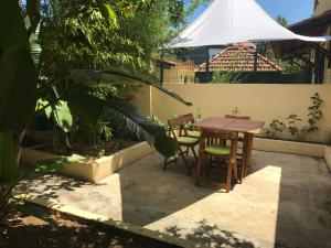 een patio met een tafel en stoelen en een witte parasol bij A casa do bairro in Lissabon