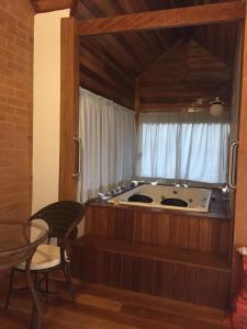 a kitchen with a stove in a room with a window at Pousada Villa do Luar in Monte Verde