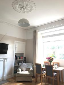uma sala de estar com uma mesa e uma cadeira em A Wee Cottage In Dunfermline em Dunfermline