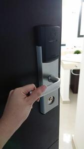a hand is pushing a drink dispenser on a refrigerator at Hotel MB in Campeche