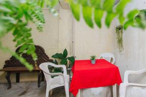 a red table with white chairs and a red table cloth at Las Huellas del Caminante in Catemaco +2 photos